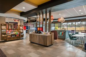 a restaurant with a waiting area with tables and chairs at Tru By Hilton Augusta Washington Road in Augusta