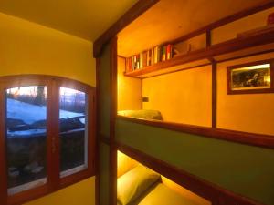 a room with a hallway with shelves and a window at Shangri-La Travellers' Hostel in Castel dellʼAlpi