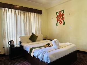 a hotel room with two beds and a window at Boudha Orange Hotel in Kathmandu