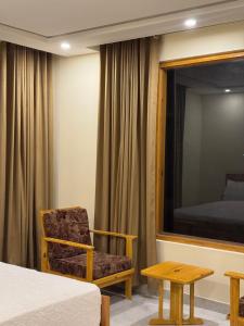 a room with a bed and a chair and a mirror at Northlanders Guest House Skardu in Skardu