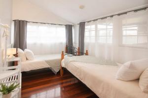 two beds in a room with a window at Busselton Central Accommodation in Busselton