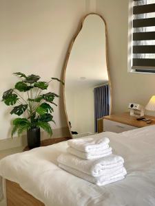 a pile of towels sitting on a bed with a mirror at Bắp Villa Huế in Thôn Lại Thê