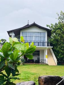 a house with a green yard with a tree at Smart heritage in Galaha Town