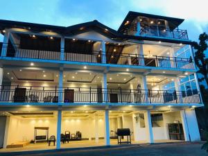 a large white building with a balcony and tables at Smart heritage in Galaha Town
