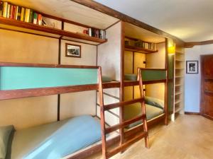 a bunk bed room with two bunk beds and a ladder at Shangri-La Travellers' Hostel in Castel dellʼAlpi