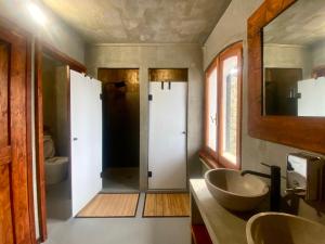 a bathroom with two sinks and a toilet at Shangri-La Travellers' Hostel in Castel dellʼAlpi +17 photos