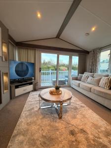 a living room with a couch and a table at Archerfield Luxe Lodge in Port Seton