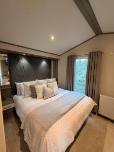 a bedroom with a large white bed with a window at Archerfield Luxe Lodge in Port Seton
