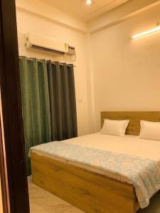 a bedroom with a bed with a green curtain at Baloonrooms in Gorakhpur