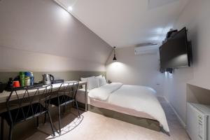 a small bedroom with a bed and a desk at Hotel HL in Seoul
