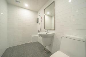 a white bathroom with a toilet and a sink at Hotel HL in Seoul +8 photos