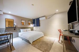 a bedroom with a bed and a desk and a television at Hotel HL in Seoul