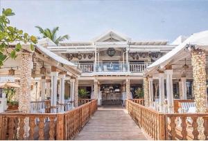 a large white house with a wooden walkway at Boca del mar III in Boca Chica