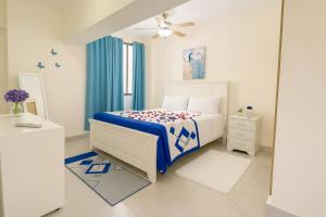 a white bedroom with a bed and a window at Boca del mar III in Boca Chica +37 photos
