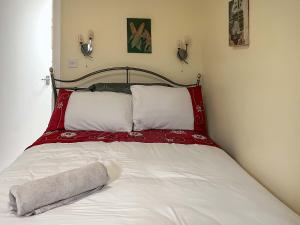 a bed with a red and white blanket on it at The Stable Room - Uk51595 in Berwick-Upon-Tweed