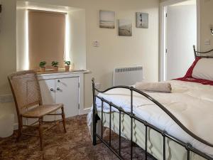 a bedroom with a bed and a chair at The Stable Room - Uk51595 in Berwick-Upon-Tweed