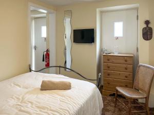 a bedroom with a bed and a dresser and a television at The Stable Room - Uk51595 in Berwick-Upon-Tweed