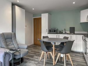a living room with a table and chairs and a kitchen at Peebles Apartment in Peebles