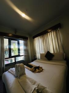 a bedroom with two beds with towels on them at Boudha Orange Hotel in Kathmandu +3 photos