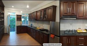 a large kitchen with wooden cabinets and a kitchen with wooden floors at Hillside Home in Kundasale