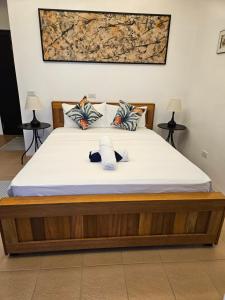 a bedroom with a bed with white sheets and pillows at Punta Private Beach Resort in San Teodoro