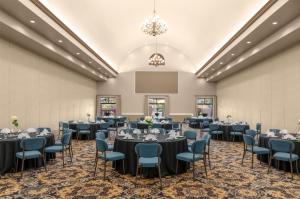 ein Ballsaal mit Tischen und Stühlen sowie einer Leinwand in der Unterkunft DoubleTree by Hilton Phoenix-Gilbert in Gilbert