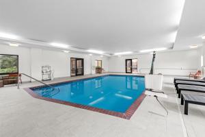 ein Schwimmbad in einem Raum mit einem Tisch und einem Stuhl in der Unterkunft Hampton Inn Harrison in Harrison