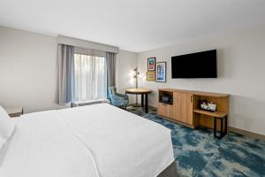 ein Hotelzimmer mit Bett und Flachbildfernseher in der Unterkunft Hampton Inn Harrison in Harrison