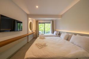 a bedroom with a large bed and a tv at Orkide Bodrum in Bodrum City