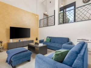 a living room with two blue couches and a tv at Villa Giulia by IstriaLux in Manjadvorci