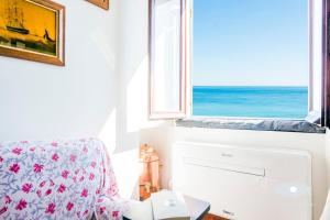 a room with a chair and a window with the ocean at La cabina del capitano in Bogliasco