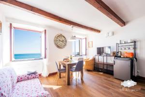 a living room with a table and a clock on the wall at La cabina del capitano in Bogliasco