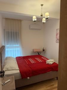 a bedroom with a bed with a red blanket at Lux stan in Bar