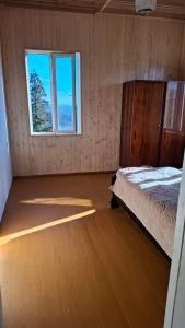 an empty room with a bed and a window at სახლი ბუნებაში House in nature in Ts'ikhisdziri