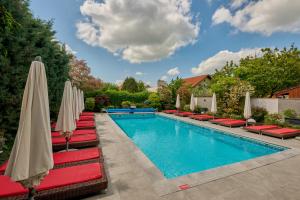 a swimming pool with lounge chairs and umbrellas at Nora Prestige in Timişoara