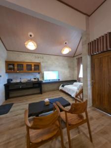 a living room with a bed and a table and chairs at Istana Ombak Eco Resort in Pacitan