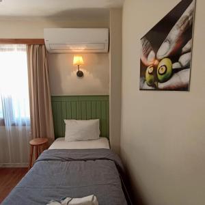 a bedroom with a bed and a picture on the wall at Dalgaci Deniz Konukevi in Ayvalık