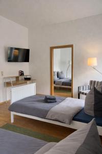 a bedroom with a large bed and a mirror at Fortuna Inn Salzmünde in Salzatal