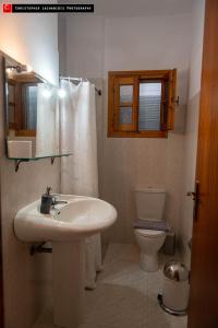 a bathroom with a sink and a toilet at Mokos Rooms in Perdika