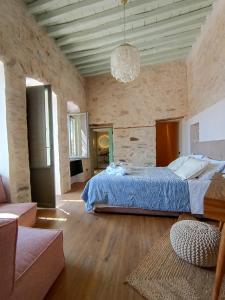 a large bedroom with a bed and a couch at Nymfea Ano Syros in Ano Syros