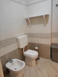 a bathroom with a toilet and a sink at Corte DON BOSCO 5 in Monfalcone