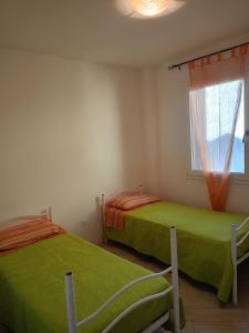 two beds in a room with a window at Corte DON BOSCO 5 in Monfalcone