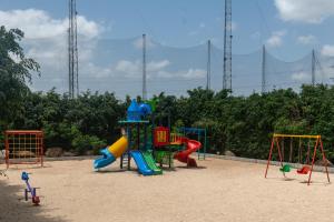 a playground with colorful playground equipment in the sand at Clover Greens Golf Course & Resort - Attibele, Hosur in Sarjāpur