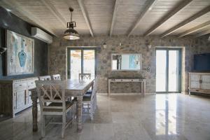 a dining room with a wooden table and chairs at Βίλα Αοιδή in Galaxidi