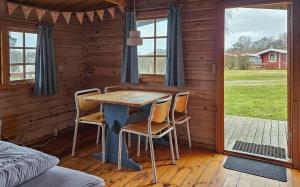 a dining room with a table and chairs in a cabin at Bygholm Camping og aktiviteter in Vesløs