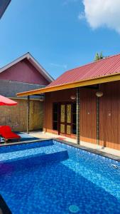 a house with a swimming pool next to a building at Sun Resort And Villa Gili Trawangan in Gili Trawangan