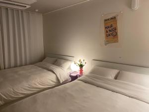 two beds sitting next to each other in a bedroom at Little Suite Daegu-Central Residential Hotel in Daegu