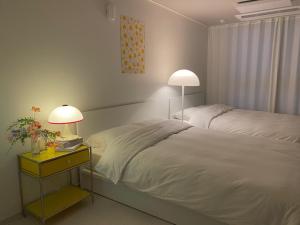 a bedroom with a bed with two lamps on it at Little Suite Daegu-Central Residential Hotel in Daegu +133 photos