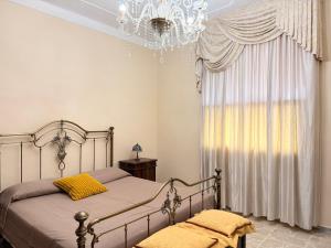 a bedroom with a bed with a chandelier and a window at Tra Mare e Relax in Gallipoli