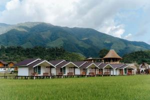 a row of houses in a field with mountains in the background at สะปันดีวิว Sapan Dee View บ่อเกลือ น่าน in Ban Huai Ti +67 photos
